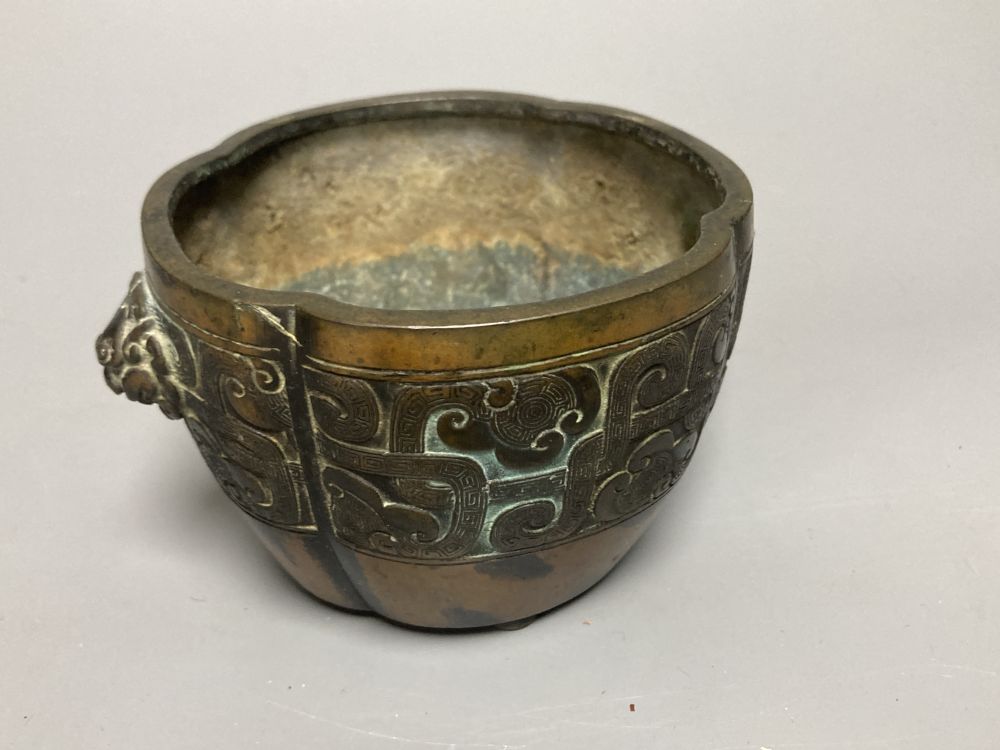 A Chinese bronze lobed censer, 18th century, archaistic cast band, on four disc feet, 11cm diameter